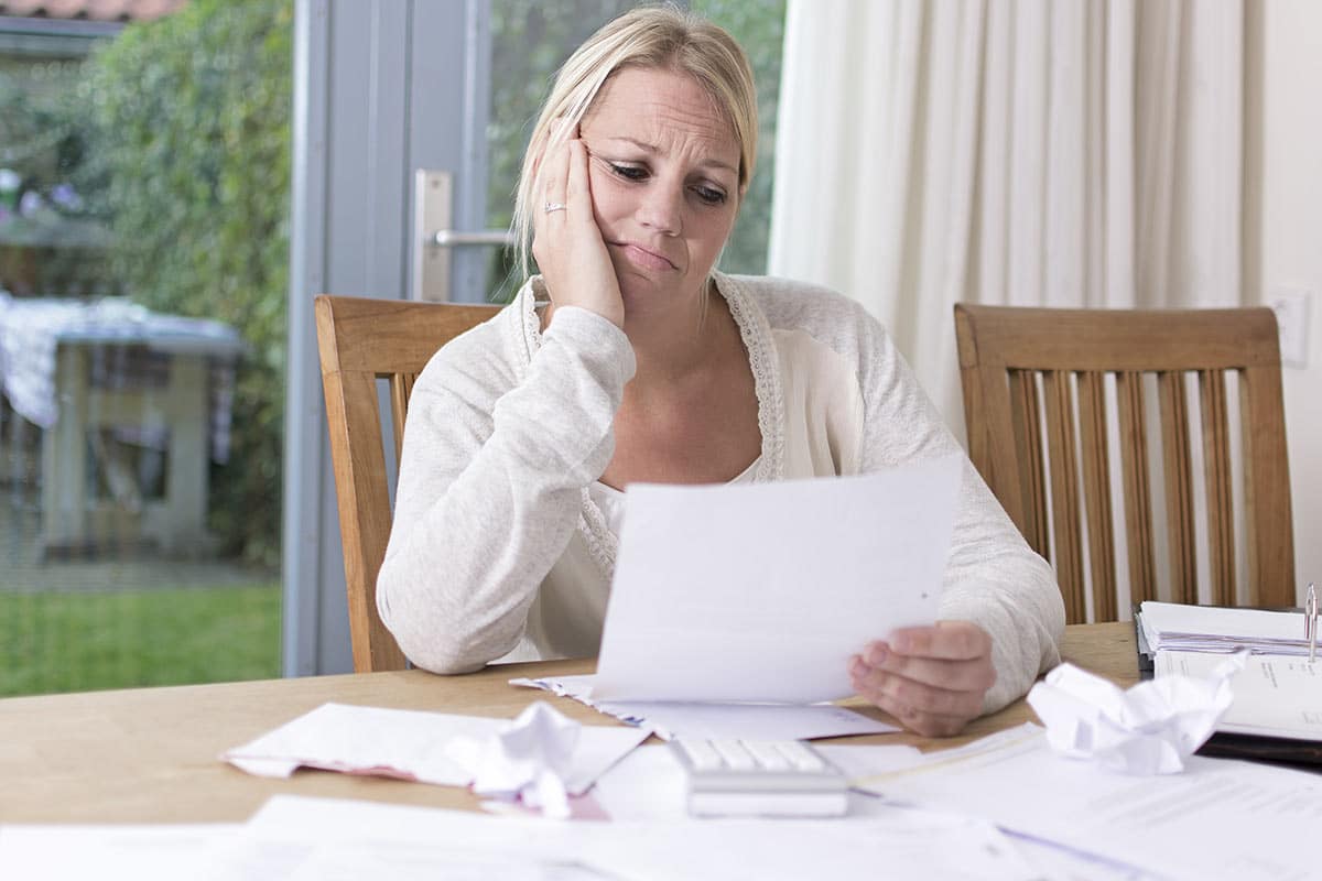 Woman looking at credit report how debt can affect mortgage